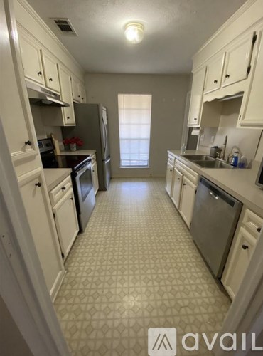 A kitchen with white cabinets and appliances.