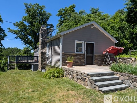 A small house with a stone chimney and a porch.