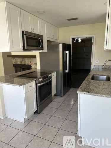A kitchen with white cabinets and a granite countertop.