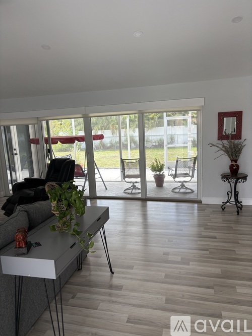 A living room with a grey sofa and a wooden floor.