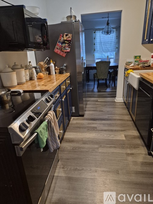 A kitchen with a black stove top oven and a black microwave above it.