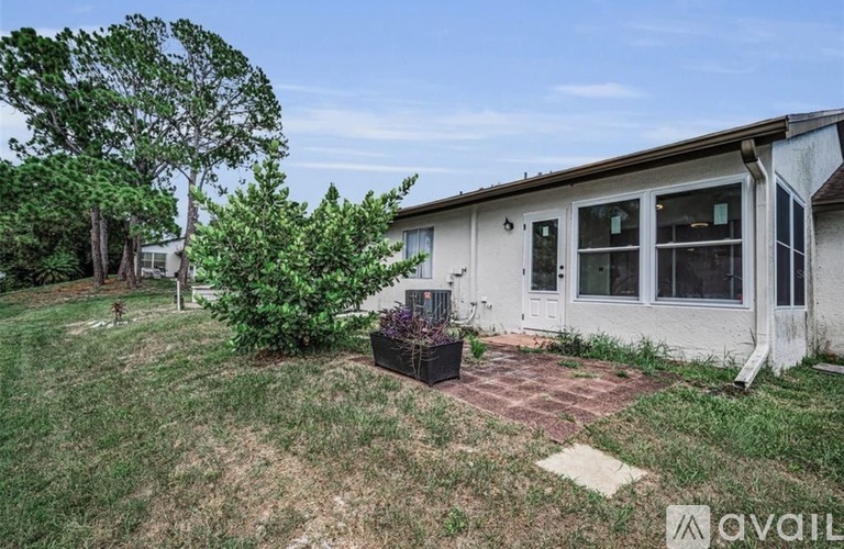 A house with a white exterior and a small garden in front.