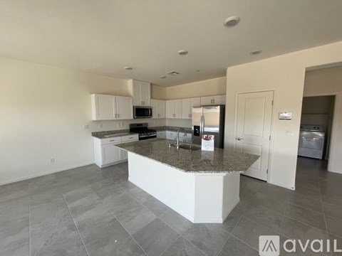 A kitchen with a granite countertop and white cabinets.