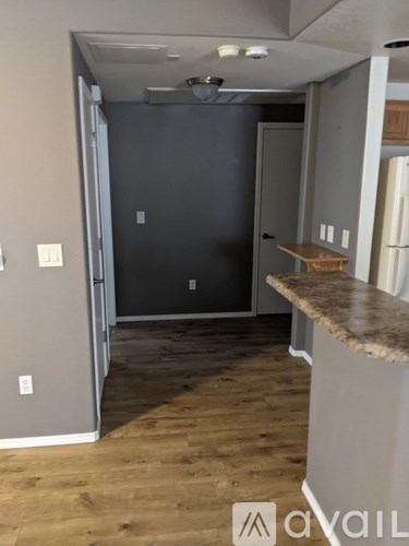 A kitchen area with a counter and a door leading to another room.