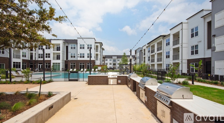 A row of modern apartment buildings with a pool in the foreground.