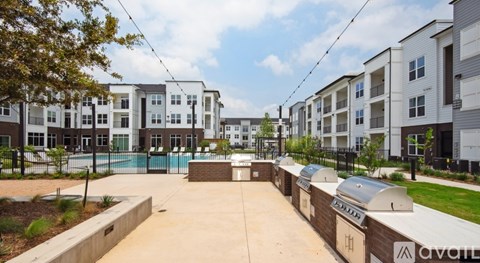 A row of modern apartment buildings with a pool in the foreground.