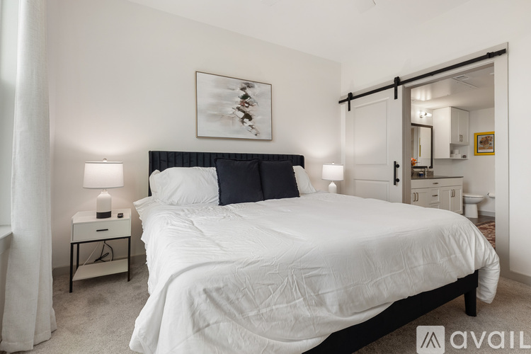 A bedroom with a large bed and a painting above it.