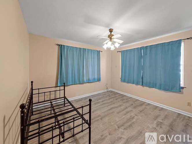 A bedroom with a four-poster bed and a ceiling fan.