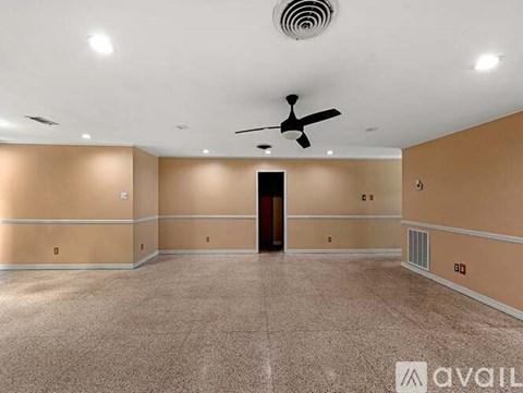 A spacious room with a ceiling fan and a door in the middle.