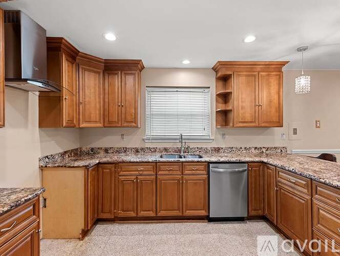 A kitchen with wooden cabinets and granite countertops.