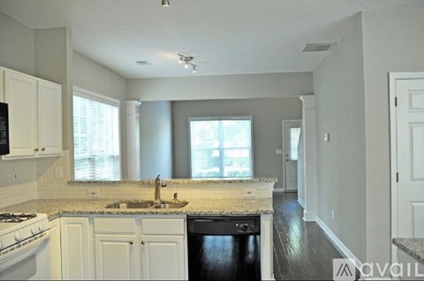 A kitchen with white cabinets and a black dishwasher.