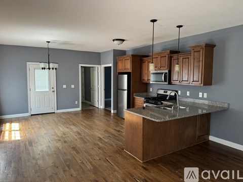 A kitchen with wooden cabinets and a granite countertop.