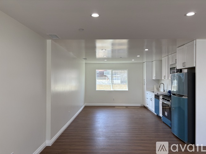A kitchen with a blue refrigerator and wooden floors.