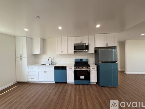 A kitchen with white cabinets and a blue dishwasher.