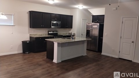 A kitchen with black cabinets and a granite countertop.