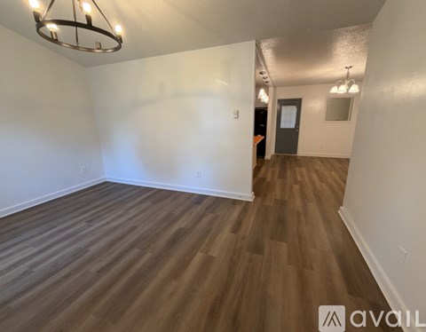 A room with wooden flooring and a chandelier.