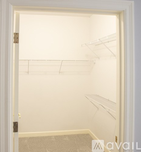 Empty white refrigerator with three shelves.
