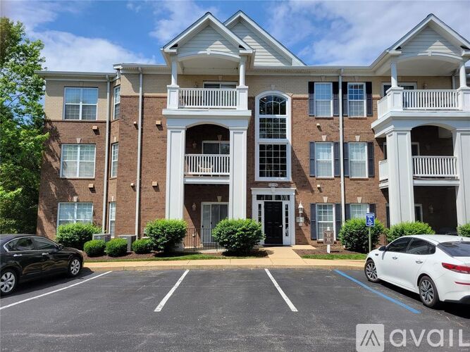 A large brick apartment building with a white balcony on the second floor.