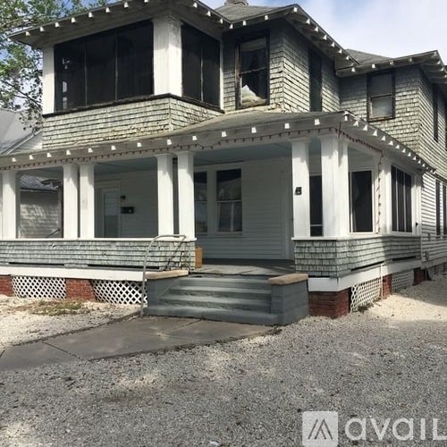 A house with a grey front porch and a white door.
