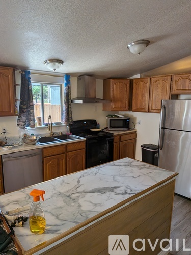 A kitchen with wooden cabinets and a marble countertop.