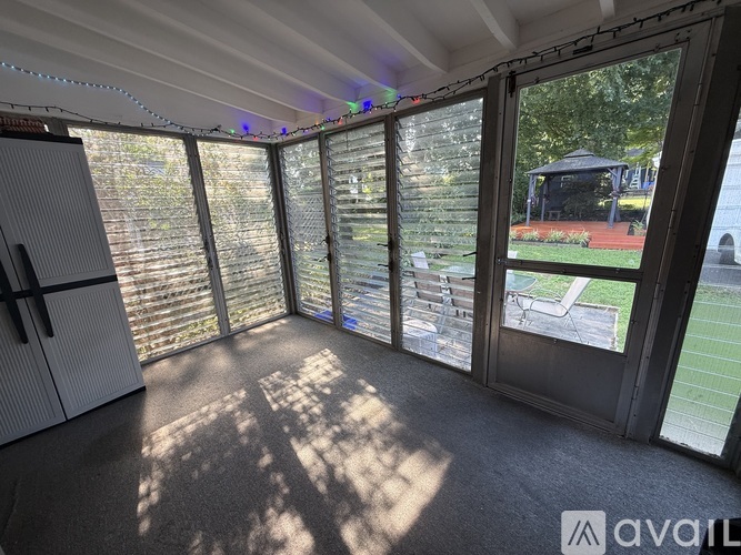 A sunny room with a view of a garden and a gazebo.