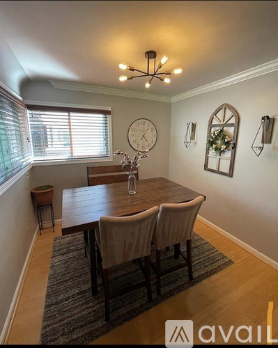 A dining room with a wooden table and chairs.