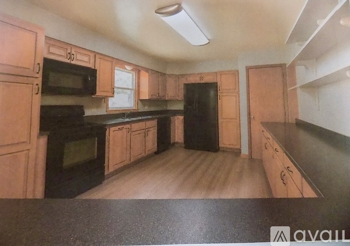 A kitchen with wooden cabinets and black appliances.