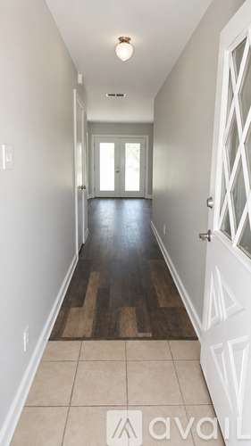A long hallway with a white door at the end.