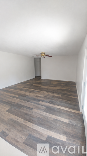 A room with a wooden floor and a ceiling fan.