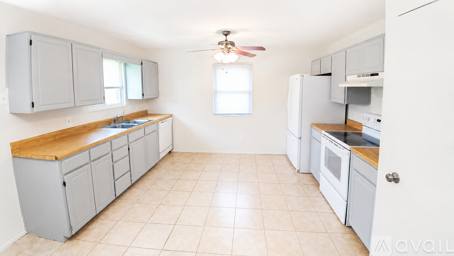 A kitchen with white appliances and wooden countertops.