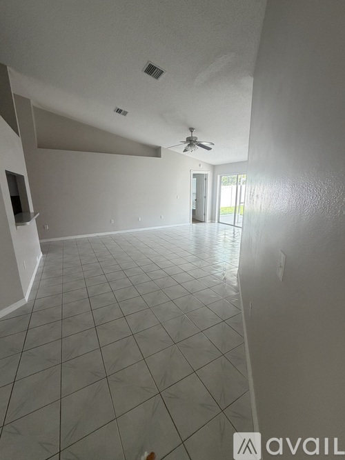 A spacious room with a ceiling fan and tiled flooring.