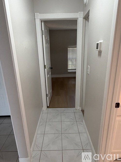 A hallway with a doorway leading to another room.