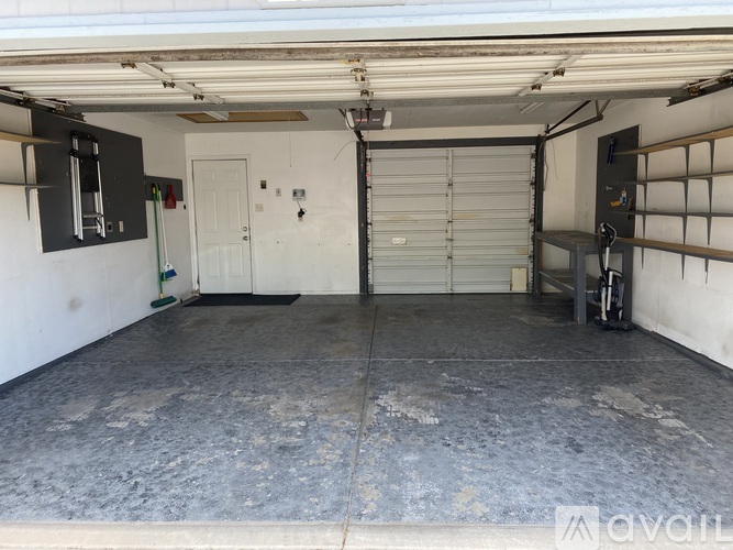 A large garage with a concrete floor and a white door.