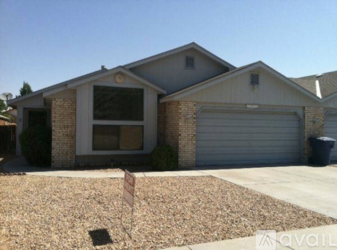A house with a garage and a sign in front.