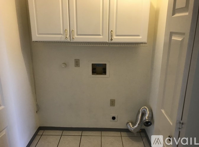 A bathroom with a white tiled floor and a white cabinet above it.