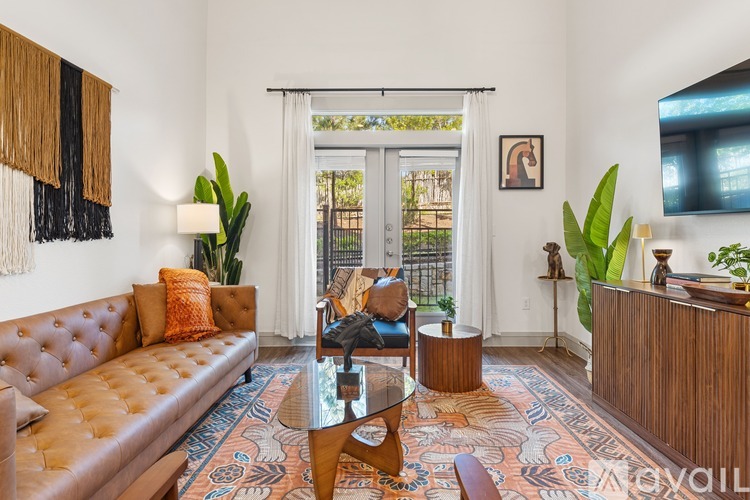 A living room with a brown leather sofa and a glass coffee table.