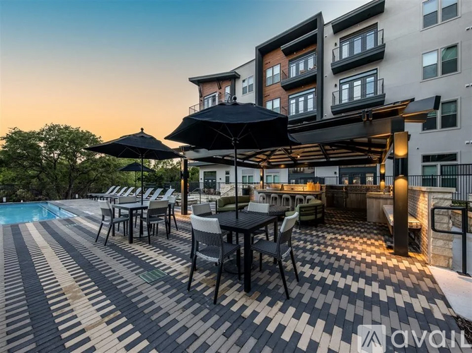 A patio area with a table set for dining and a pool in the background.