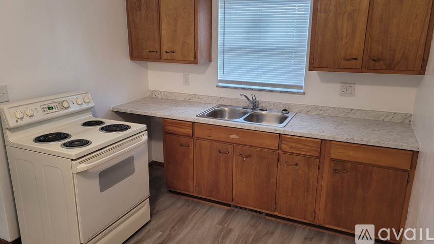 A kitchen with a white stove and wooden cabinets.