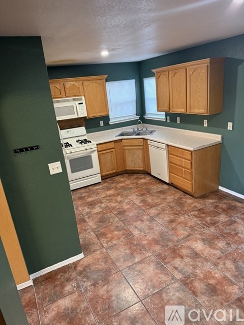 A kitchen with a tile floor and wooden cabinets.