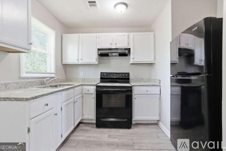 A kitchen with white cabinets and a black oven.