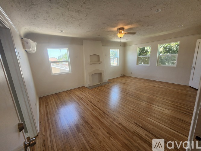A room with wooden flooring and a ceiling fan.