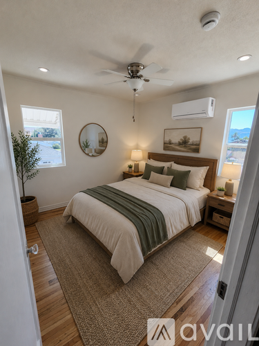 A bedroom with a bed, a ceiling fan, and a window.