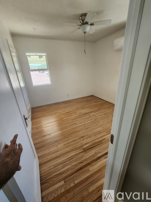 A room with wooden flooring and a ceiling fan.