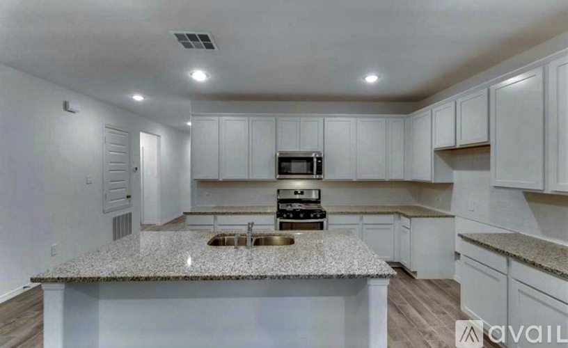 A kitchen with white cabinets and a granite countertop.