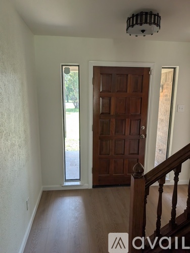 A room with a wooden door and a staircase.