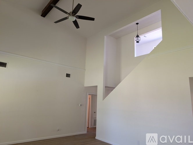 A room with a ceiling fan and a light hanging from the ceiling.