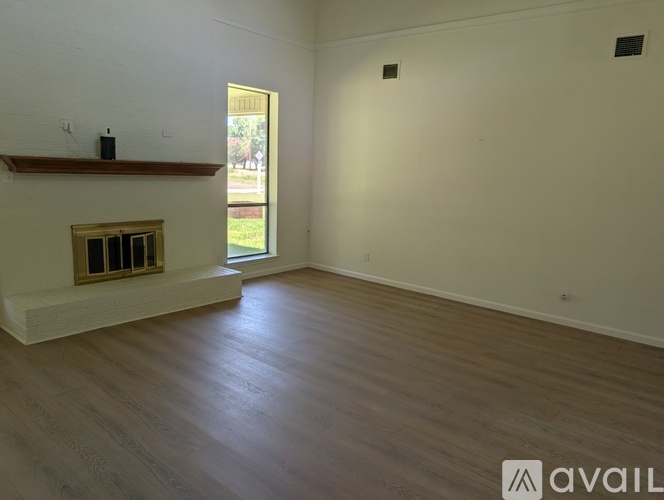 A room with a fireplace and wooden floors is available for rent.