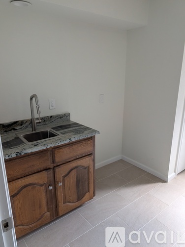 A kitchen with a sink and wooden cabinets.