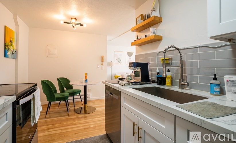 A kitchen with a marble countertop and green chairs.