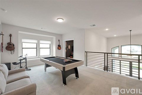 A room with a pool table and a bicycle.